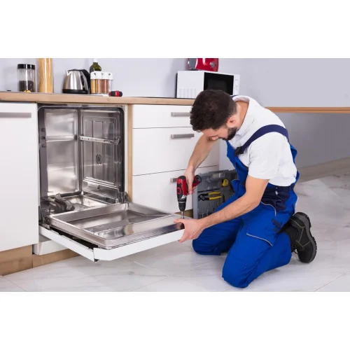 A household appliance repairman repairs a dishwasher.