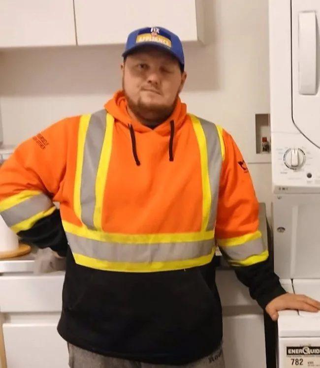 The washing machine repairman was repairing the dryer.