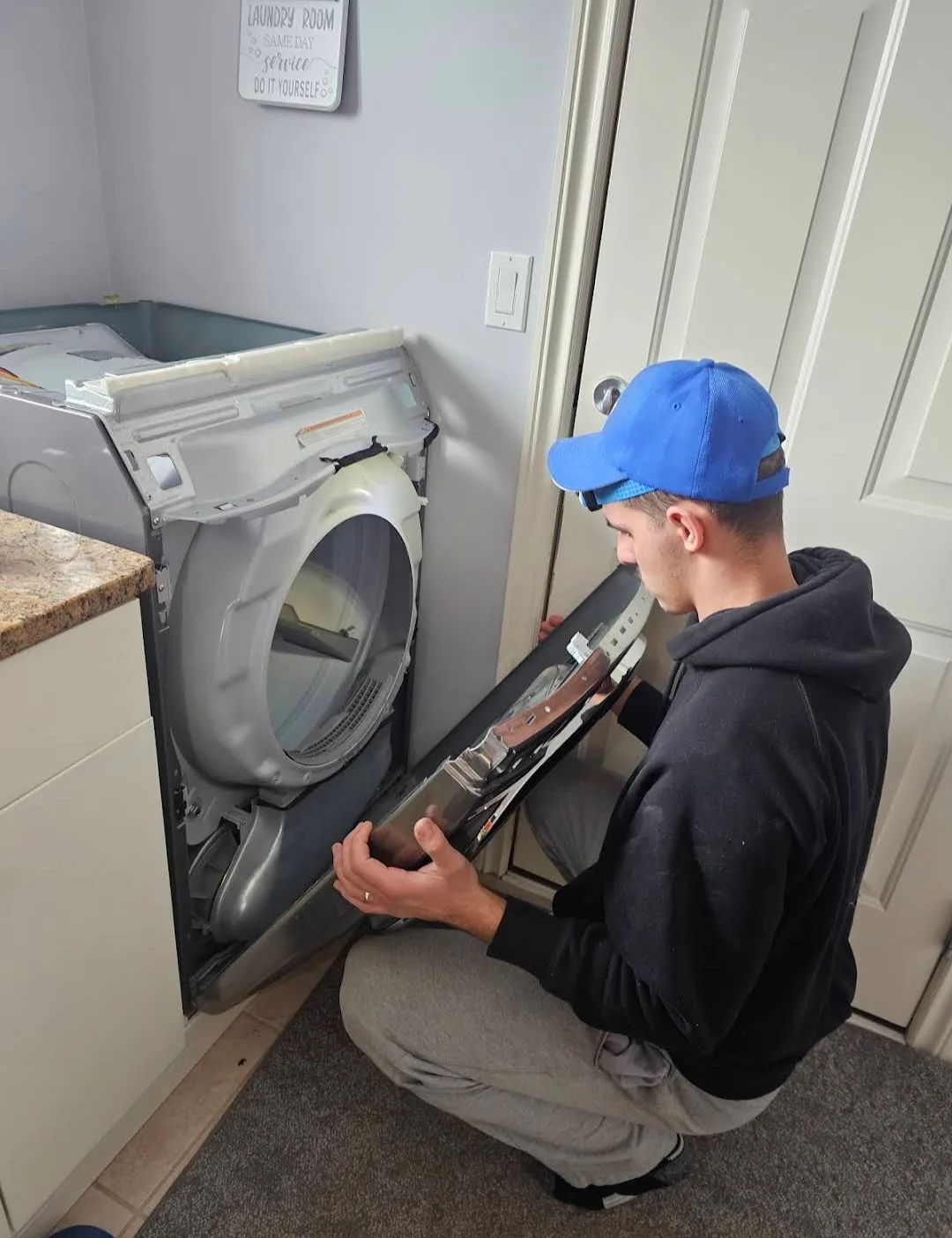 Appliance repairman fix-appliance.caing a dryer.
