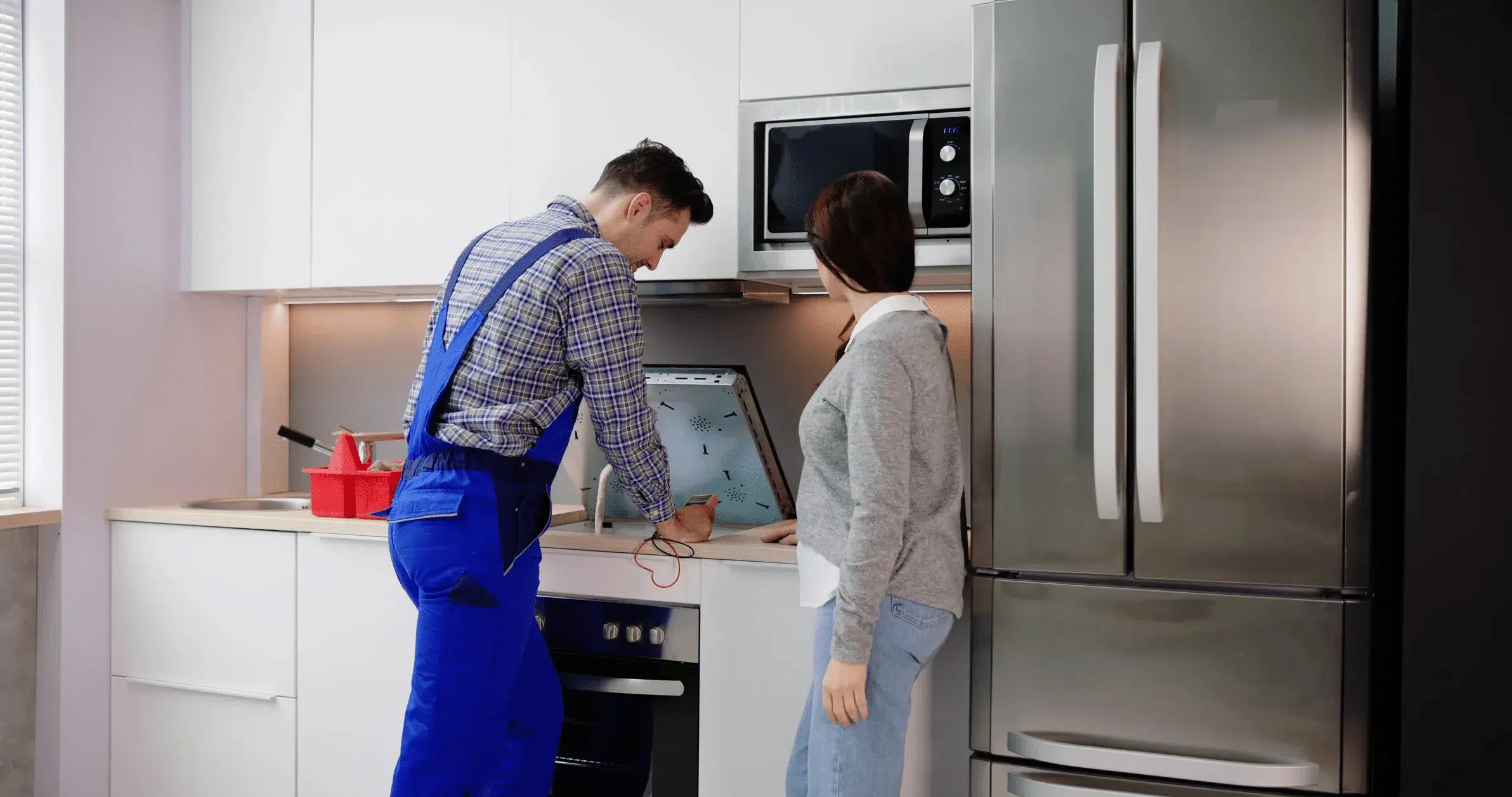 A cooktop repair technician diagnoses the problem and shows it to the customer.
