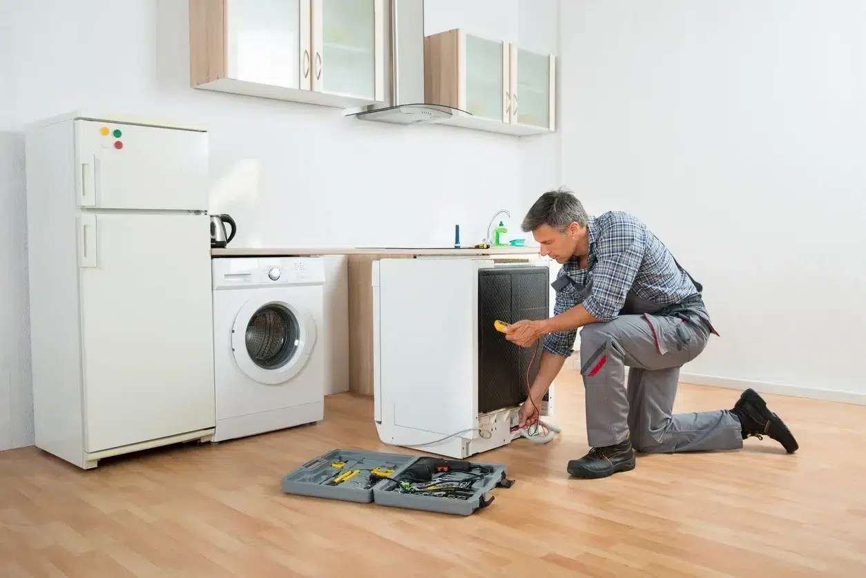 appliance repairman is repairing a dishwasher in Kitchener
